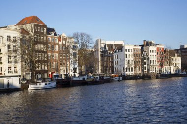 Amsterdam kanal kemerinde sokak hayatı olan tipik Hollanda mimari binaları  