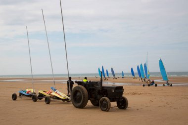 Plajda bir blokart, arazi ya da kum yelkenli araba ya da yük arabasıyla, rüzgarla çalışan üç tekerlekli ve yelkenli bir kara aracı ile yapılan bir yarışma.