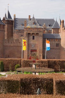 Kırpılmış kayın çitleriyle resmi bahçeli antik bir kale.