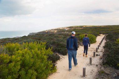 Denizin üzerinde yürüyüş yapan çift.