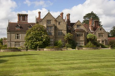 Geniş çimenli ve geniş çiçek bahçeli, tipik bir İngiliz kır evi.