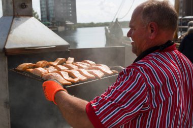 Barajda balık pişiren bir adamın görüntüsü.