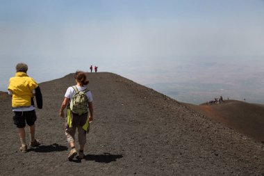 Bir grup turist güzel bir dağ manzarasında yürüyor.