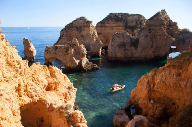 Tipik ve turistik engebeli ve çökmekte olan dengesiz Algarve kayalık kıyıları denizlerde kayalık tepeler, mağaralar, kemerler ve gizli cennet kumsalları