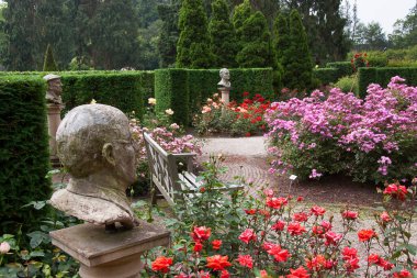 Botanik bahçesi manzaralı, heykeller ve çiçek açan.