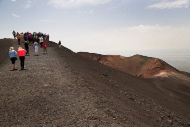 Bir grup turist güzel bir dağ manzarasında yürüyor.