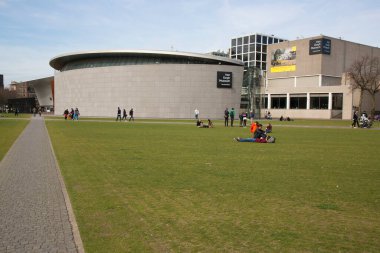 Şehir parkındaki yeşil çimenlikteki insanlar, seyahat çekimleri.