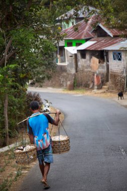 Sepetli bir adam sokakta yürüyor.