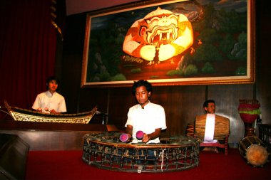 Geleneksel Thai kostümlü bir adamın portresi sahnede sergileniyor.