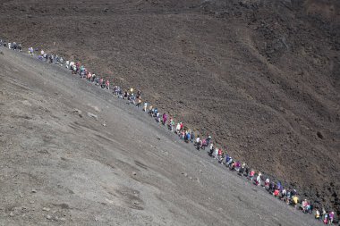 Bir grup turist güzel bir dağ manzarasında yürüyor.