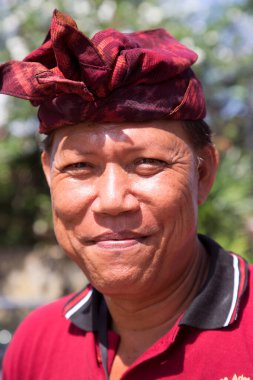 Şenlikli saç bandı takmış Asyalı bir adamın portresi.