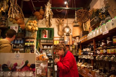 Çeşitli yiyecekleri olan bir dükkandaki insanlar.