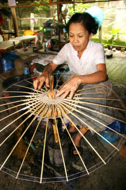 Atölyede yeni şemsiye yapan kadın portresi