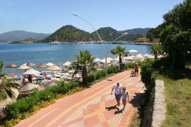 Dinlenen insanlarla güneşli halk plajı sahnesi