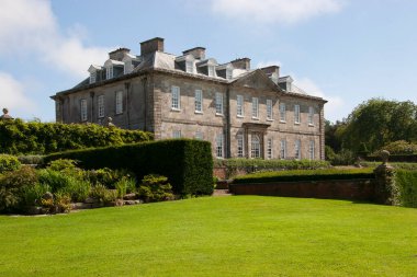 Kırsaldaki tipik bir İngiliz kır evi. Geniş çimleri ve süslemeleri olan geniş bir bahçesi var.