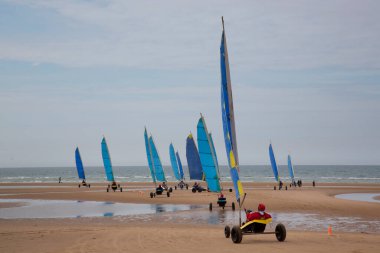Plajda bir blokart, arazi ya da kum yelkenli araba ya da yük arabasıyla, rüzgarla çalışan üç tekerlekli ve yelkenli bir kara aracı ile yapılan bir yarışma.