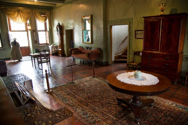 Eski evin içi, müze sahnesi eski moda kıyafetler giyen işçilerle dolu.