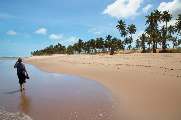 Kumsalda sırt çantalı takım elbiseli bir adam.