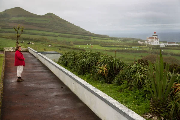 Kumsalda sırt çantalı kırmızı elbiseli bir kadın.