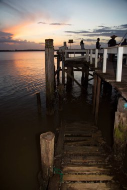 Sahilde gün batımında gökyüzü olan ahşap iskele