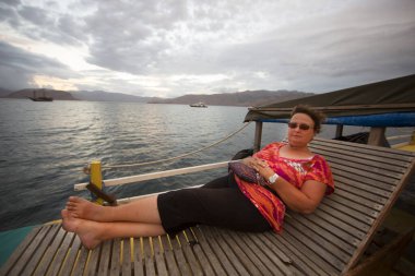 İnsanlar gün batımında rıhtımda