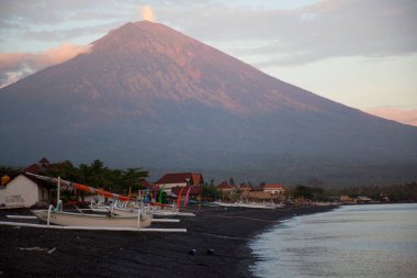 Sahilde demirlemiş kayıklar ve arka planda dağlar.