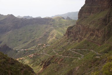 Yeşil dağları ve bulutlu gökyüzü olan güzel bir manzara.
