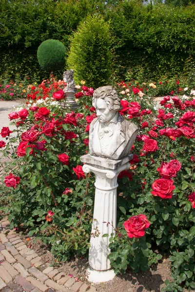 Botanik bahçesi manzaralı, heykeller ve çiçek açan.