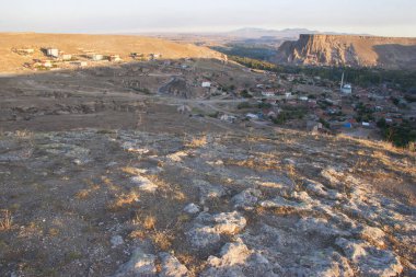 Tipik Kapadokyaca Vadisi köyü, taşlara kazınmış tarihi kaya konutları ve kiliselerle aşınmış dağın yanında.