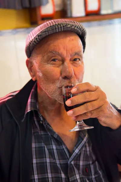 Büyük adam kadehten şarap içiyor.