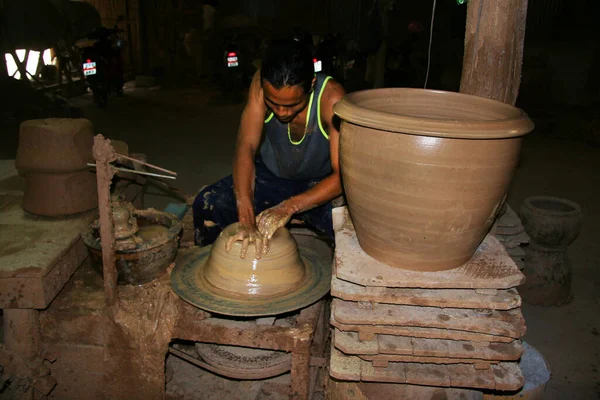 Çömlekçide kil tenceresi olan bir işçi. 