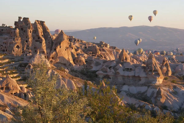 Turistlerle dolu sıcak hava balonları ulusal parkın üzerindeki volkanik bir arazide bunaltıcı manzaranın keyfini çıkarıyor.