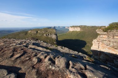 Güneşin yemyeşil olduğu kayalık manzaralı güzel bir manzara.