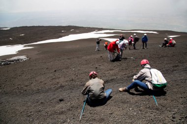 Bir grup turist güzel bir dağ manzarasında yürüyor.
