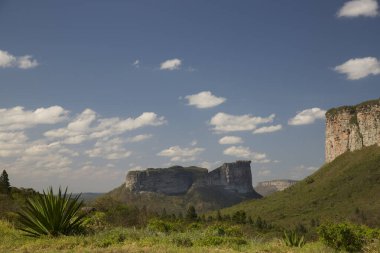 Güneşin yemyeşil olduğu kayalık manzaralı güzel bir manzara.