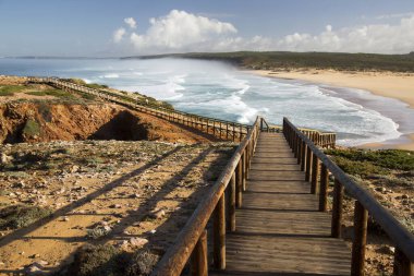 Tepe doğal kıyı manzarası, kum tepeleri ve uzun tahta kaldırımları olan alçak çalılıklar. 