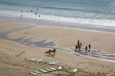 İnsanlar Atlantik Okyanusu kıyısında plajın tadını çıkarıyorlar.