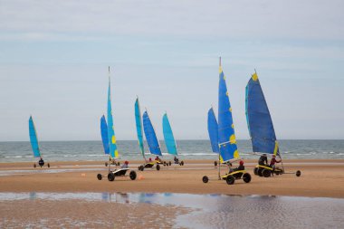 Plajda bir blokart, arazi ya da kum yelkenli araba ya da yük arabasıyla, rüzgarla çalışan üç tekerlekli ve yelkenli bir kara aracı ile yapılan bir yarışma.