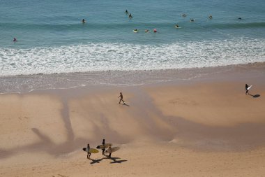 İnsanlar Atlantik Okyanusu kıyısında plajın tadını çıkarıyorlar.
