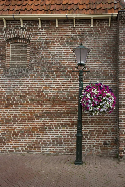 Gammal Tegelvägg Med Röda Blommor — Stockfoto