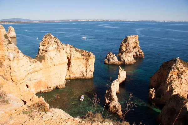 Tipik ve turistik engebeli ve çökmekte olan dengesiz Algarve kayalık kıyıları denizlerde kayalık tepeler, mağaralar, kemerler ve gizli cennet kumsalları