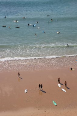 İnsanlar Atlantik Okyanusu kıyısında plajın tadını çıkarıyorlar.