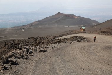Sırt çantalı bir kadın yol ve dağ boyunca yürüyor, seyahat konsepti.