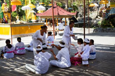 İnsanlar eski Tayland tapınağı bölgesinde karada oturuyorlar.