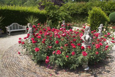 Botanik bahçesi manzaralı, heykeller ve çiçek açan.