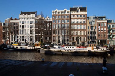 Amsterdam kanal kemerinde sokak hayatı ve mobilyalarla tipik Hollanda mimari binaları