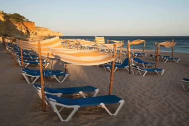 Plastik şezlonglar sahilde sıra sıra dizilmiş.