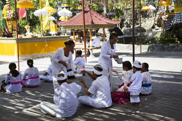 İnsanlar eski Tayland tapınağı bölgesinde karada oturuyorlar.