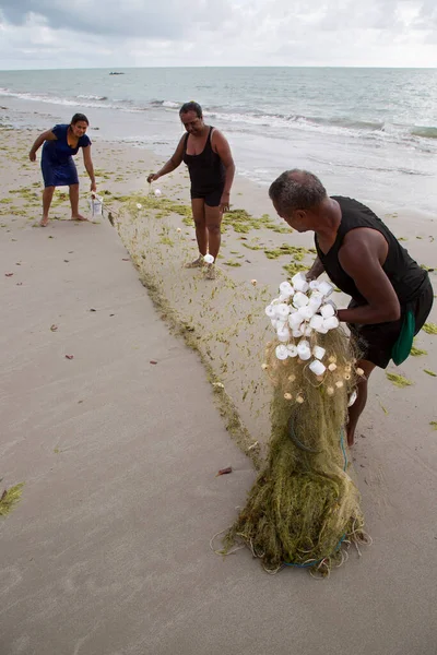 Sahilde ağlarla çalışan insanlar, seyahat çekimleri.