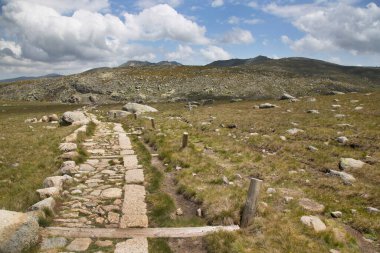 Bulutlu gökyüzünün altındaki dağlık manzaranın görüntüsü
